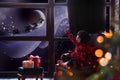 Cute little boy waiting for Santa Claus near window. Christmas holiday Royalty Free Stock Photo