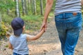 Cute little boy walking in park holding parents hand. Happy family and lifestyle concept Royalty Free Stock Photo