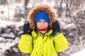 Cute little boy walking under the snow. Happy smiling boy in winter clothes. Snowy winter weather. Beautiful winter park. Kid Royalty Free Stock Photo