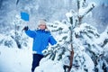 Cute little boy wearing warm clothes playing on winter forest Royalty Free Stock Photo