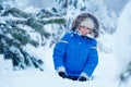 Cute little boy wearing warm clothes playing on winter forest Royalty Free Stock Photo