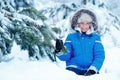 Cute little boy wearing warm clothes playing on winter forest Royalty Free Stock Photo