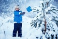 Cute little boy wearing warm clothes playing on winter forest Royalty Free Stock Photo