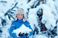 Cute little boy wearing warm clothes playing on winter forest Royalty Free Stock Photo