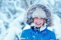 Cute little boy wearing warm clothes playing on winter forest Royalty Free Stock Photo