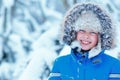 Cute little boy wearing warm clothes playing on winter forest Royalty Free Stock Photo