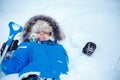 Cute little boy wearing warm clothes playing on winter forest Royalty Free Stock Photo