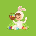 Cute little boy in a white bunny costume holding basket with painted eggs, kid having fun on Easter egg hunt vector Royalty Free Stock Photo