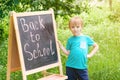 Cute little boy writting on blackboard outdoor . Back to school concept. Royalty Free Stock Photo