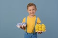 Child and Easter. Smiling blond boy, 6 years old, is holding a colors eggs.