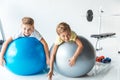 cute little boys exercising on fitness balls and smiling at camera