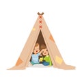 Cute little boys sitting in a tepee tent with a burning lamp, kids having fun in a hut vector Illustration