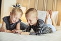 Little brother and sister lying in bed watching videos together Royalty Free Stock Photo