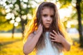 Horizontal closeup portrait at sunset of a little girl with long curly hair