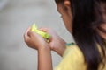 Little budgie bird on child hand. Asian child girl play with her pet bird with gentle