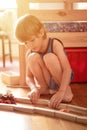 Cute little candid five year old kid boy playing at home with children`s toys cars and the wooden road on a floor of room in a co Royalty Free Stock Photo