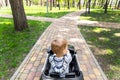 Cute little caucasain blond toddler boy enjoy having fun riding electric powered toy car by asphalt path road city park Royalty Free Stock Photo