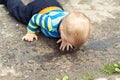 Cute little caucasian blond toddler boy having fun lying in a puddle after rain outdoors. Curious child discovering Royalty Free Stock Photo