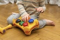 Cute little caucasian boy playing, collects multi-colored sorter constructor. Baby`s hands puzzle sorter of plastic toy. Children Royalty Free Stock Photo