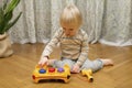 Cute little caucasian boy playing, collects multi-colored sorter constructor. Baby`s hands puzzle sorter of plastic toy. Children Royalty Free Stock Photo