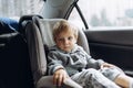 cute little caucasian boy with sad face sitting in child safety seat in a car Royalty Free Stock Photo