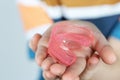 Cute little girl with blond hair is holding a pink dental myofunctional trainer Royalty Free Stock Photo