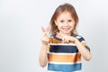 Cute little girl with blond hair is holding a pink dental myofunctional trainer Royalty Free Stock Photo