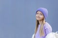 Cute little caucasian girl eight years old with blonde hair smiling outdoor. Kid wearing stylish shirt and knitted hat Royalty Free Stock Photo