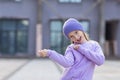 Cute little caucasian girl eight years old with blonde hair smiling outdoor. Kid wearing stylish shirt and knitted hat Royalty Free Stock Photo