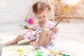 Cute little caucasian Girl enjoying Painting at the backyard with paper, water colour and art brush. Selective focus Royalty Free Stock Photo