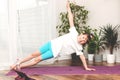 Cute little caucasian girl is practicing yoga at home. The child stands in one of the assanas. Sports, workout and fitness at home Royalty Free Stock Photo