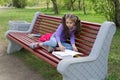 Cute little caucasian girl reading book sitting on a bench Royalty Free Stock Photo