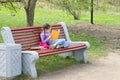Cute little caucasian girl reading book sitting on a bench Royalty Free Stock Photo