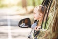 Cute little caucasian girl sitting inside the car and looking out the window. Family road trip Royalty Free Stock Photo