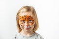 Cute little caucasian girl with tiger face painting on the white background. Close up portrait of little kid with face-painting. Royalty Free Stock Photo