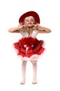 Cute little caucasian girl wearing red skirt, t-shirt with flowers and cowboy hat isolated on white background. She is dancing. Royalty Free Stock Photo