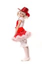 Cute little caucasian girl wearing red skirt, t-shirt with flowers and cowboy hat isolated on white background. She is dancing. Royalty Free Stock Photo