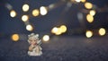 Cute little cherub against blurred Christmas lights