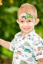 Cute little child boy with aqua make-up in park on nature at summer. Use it for baby, parenting or love conce