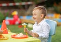 Cute little child boy with diversity friends eating cake on birthday party. kids eat dessert . Happy smile. Holding fork in hand. Royalty Free Stock Photo