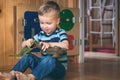 Cute little child boy playing with toy dinosaur and crocodile on busyboard background. Kid in kindergarten, nursery infant school Royalty Free Stock Photo