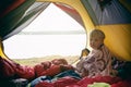 Cute little child boy sitting in camping tent, wrapped in wool blanket. Family weekend outdoor, local travel on nature, trekking, Royalty Free Stock Photo