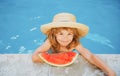 Cute little child boy in the swimming pool eating watermelon. Enjoy eating tropical fruit. Summer kids concept. Happy Royalty Free Stock Photo