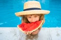 Cute little child boy in the swimming pool eating watermelon. Enjoy eating tropical fruit. Summer kids concept. Happy Royalty Free Stock Photo