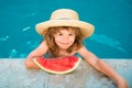 Cute little child boy in the swimming pool eating watermelon. Enjoy eating tropical fruit. Summer kids concept. Happy Royalty Free Stock Photo