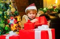 Cute little child is decorating the Christmas tree indoors. Cute little kids celebrating Christmas. Cute little child Royalty Free Stock Photo