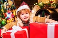 Cute little child is decorating the Christmas tree indoors. Happy little child dressed in winter clothing think about Royalty Free Stock Photo