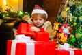 Cute little child is decorating the Christmas tree indoors. Cute little kids celebrating Christmas. Cute little child Royalty Free Stock Photo