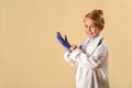 Cute little child in doctor coat with stethoscope and clipboard on lighte background