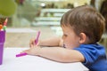 Cute little child is drawing with colorful felt-tip pens at home or kindergarten Royalty Free Stock Photo